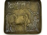 une plaque métallique sur laquelle sont représentés une vache et un zèbre