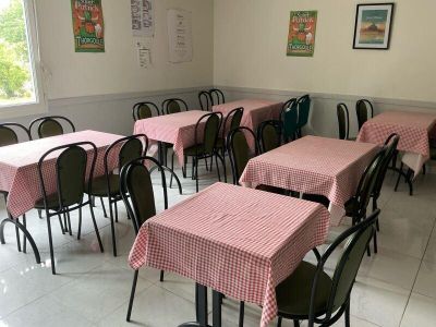 de nombreuses tables et chaises dans une pièce où les nappes sont à carreaux roses