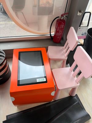 une petite table avec deux chaises et une tablette posée dessus