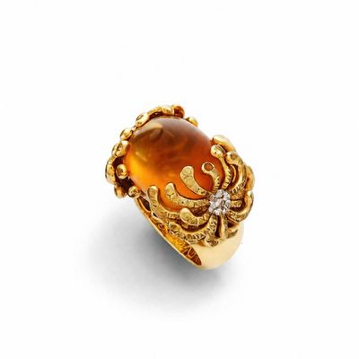 une bague en or jaune sertie d'une pierre orange et de diamants