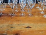 many empty wine glasses sitting on a wooden table