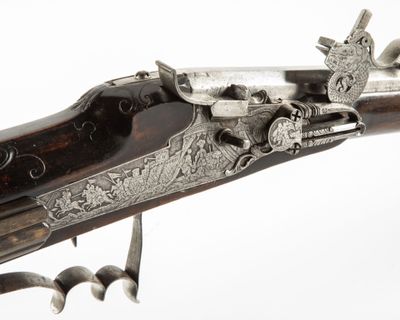 un vieux pistolet muni d'une crosse métallique, sur fond blanc