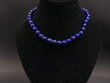 un collier de perles violettes sur un mannequin noir