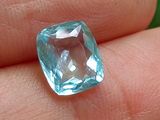 une personne tenant une topaze bleue dans la main