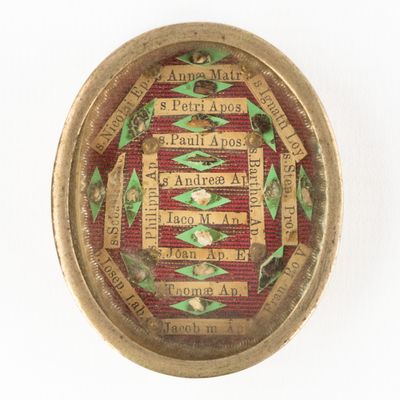 a picture of a gold and red broochle with words on it
