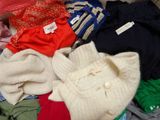 a pile of clothes sitting on top of a suitcase