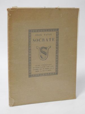 an old book sitting on top of a white table next to a white wall