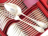 silverware in a red case on a table with a pink napkin