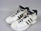 Des chaussures adidas à rayures noires et blanches sont posées sur une surface blanche