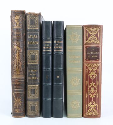 plusieurs vieux livres sont alignés sur une surface blanche