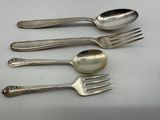 four forks and two spoons on a white surface