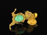 pair of gold and turquoise stone earrings on a black surface