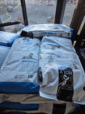 two bags of rice sitting on a bed in front of a window