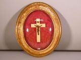 un cadre doré orné d'une croix sur fond rouge