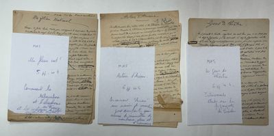 three old papers with writing on them sitting on top of a table