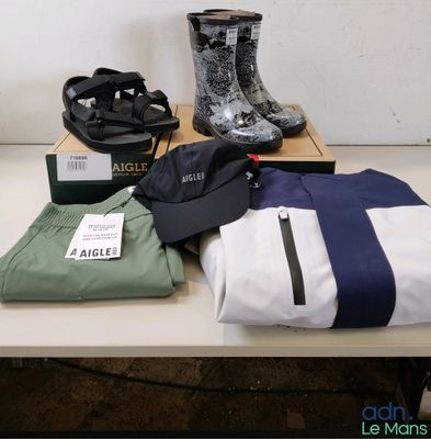 Plusieurs paires de bottes de pluie, un sac et une paire de bottes de pluie sont posés sur une table