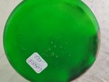 a green glass vase with a sticker on it