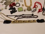 many different types of necklaces and bracelets laid out on a table
