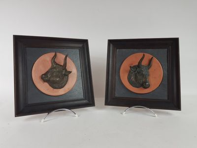 two framed pictures of a bull and a bull head on a white background