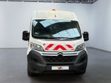 the front of a white van with a red and white stripe on it