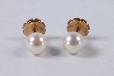 une paire de boucles d'oreilles en perles et en or sur fond blanc