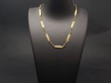 un collier à chaîne en or sur un mannequin, sur fond noir