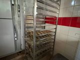 a rack with trays of dough on it in a kitchen