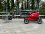 a small red tractor parked in front of a fence