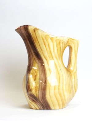 a brown and white vase sitting on a white surface