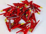 une pile de pinces rouges et jaunes posées sur une table blanche