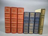 Quatre livres sont alignés sur une surface grise