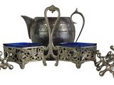 a silver tea pot and two blue cups on a stand