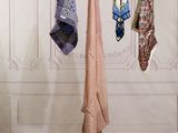 several different colored ties hanging from a clothes line in a room