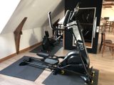 a gym room with a treadie machine and exercise mats on the floor