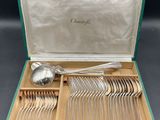 a green case with silverware in it on a table