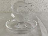 a glass figurine of a fish on a glass plate