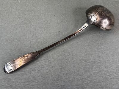 silver spoon with a spoon handle on a gray surface