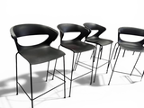 three black chairs sitting next to each other on a white surface