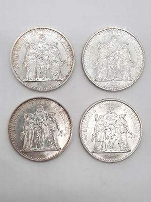 Quatre pièces de monnaie britanniques différentes sont représentées sur un fond blanc.