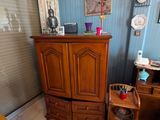 une armoire en bois dans un coin de la pièce, à côté d'une chaise