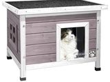 Le chat est assis dans sa niche, la porte ouverte.