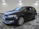 La Volkswagen Polo noire est garée dans une pièce dont le sol est en damier.