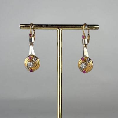 a close up of a pair of earrings on a stand