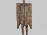 an image of a wooden sculpture of a bird on a stand