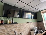 a picture of a kitchen with two televisions on the wall