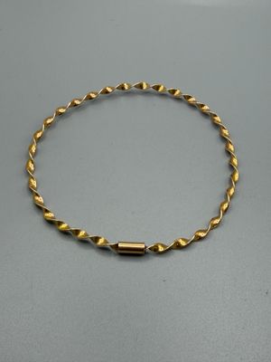 gros plan d'un bracelet en or sur une table