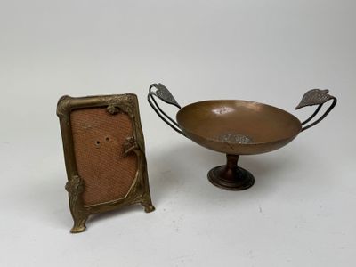 brass plate with a picture frame next to it on a white surface