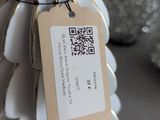 a small white christmas tree with a tag on it