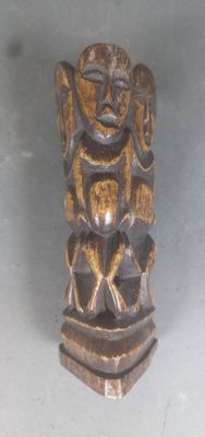 une statue en bois représentant un homme avec un oiseau sur la tête