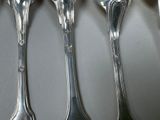 four spoons that are sitting next to each other on a table
